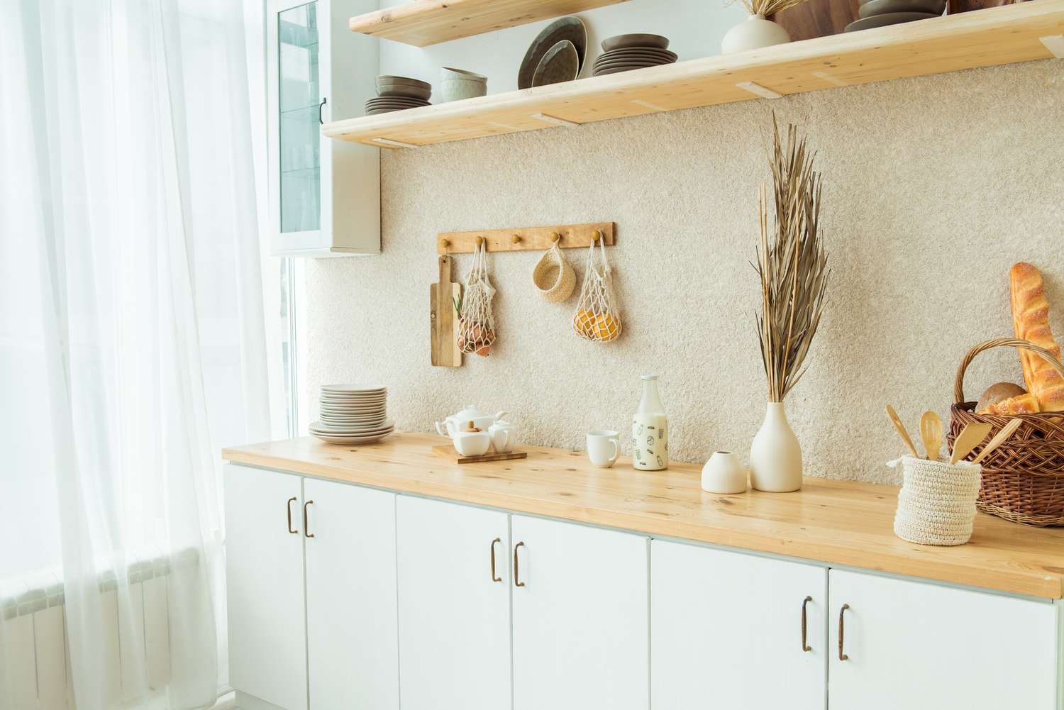 Interior of kitchen in rustic style. White furniture and wooden decor in bright cottage indoor