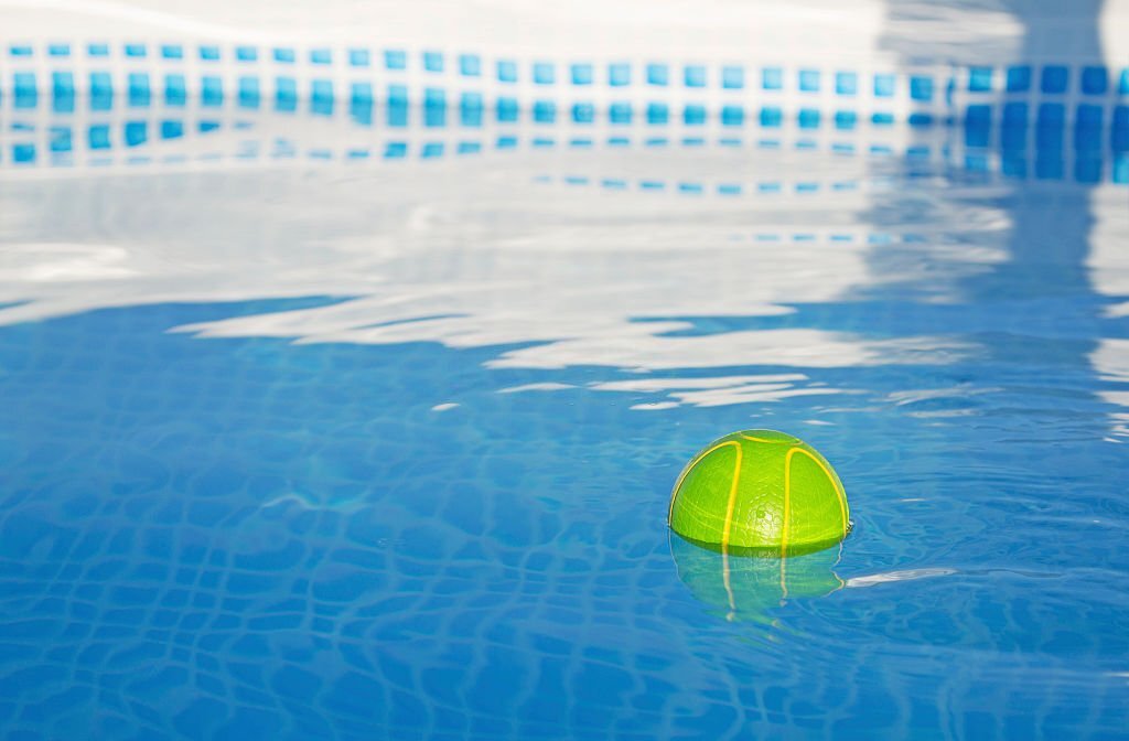 Une balle de tennis flottant dans une piscine.